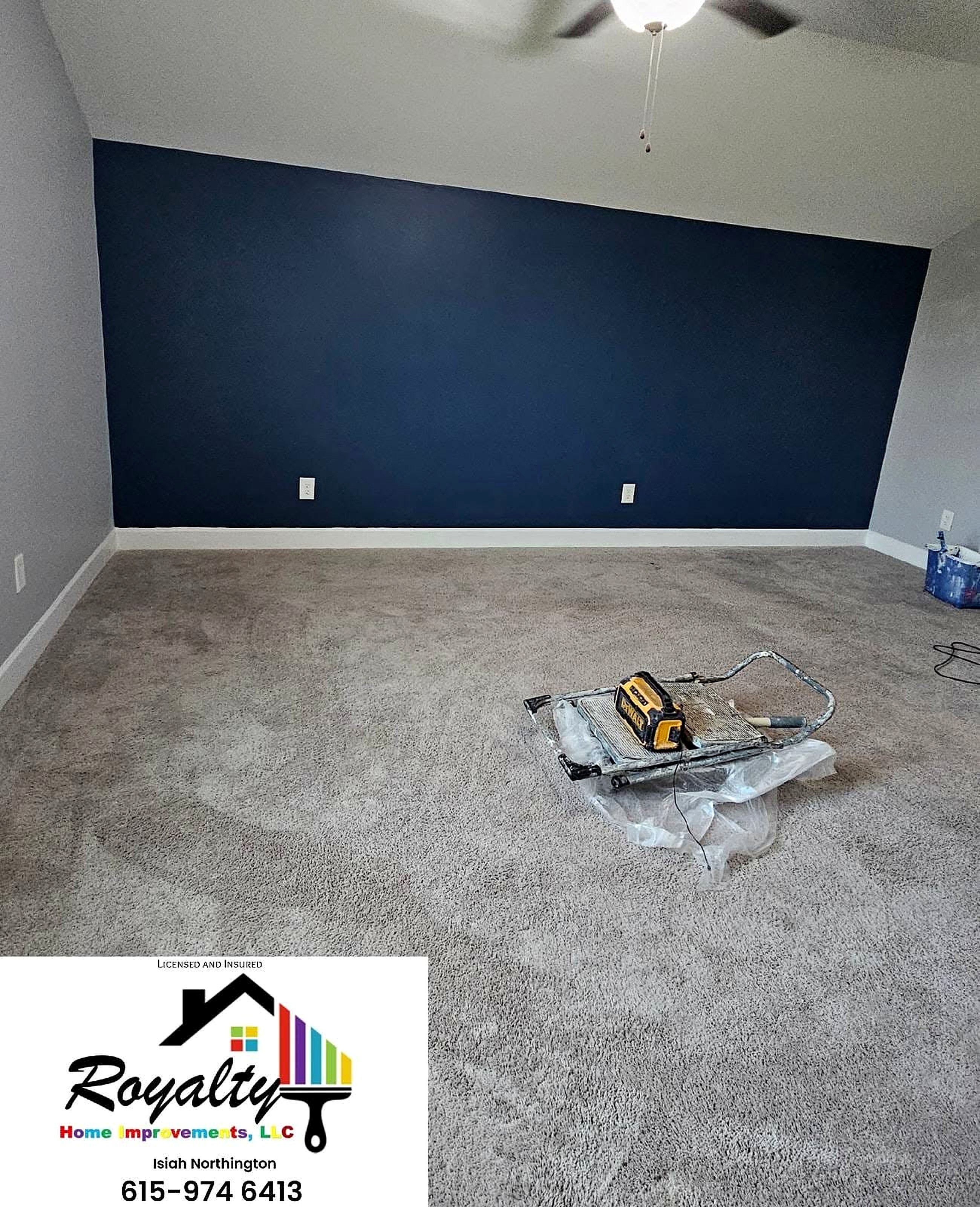 Finished bedroom with a deep navy accent wall and fresh carpet