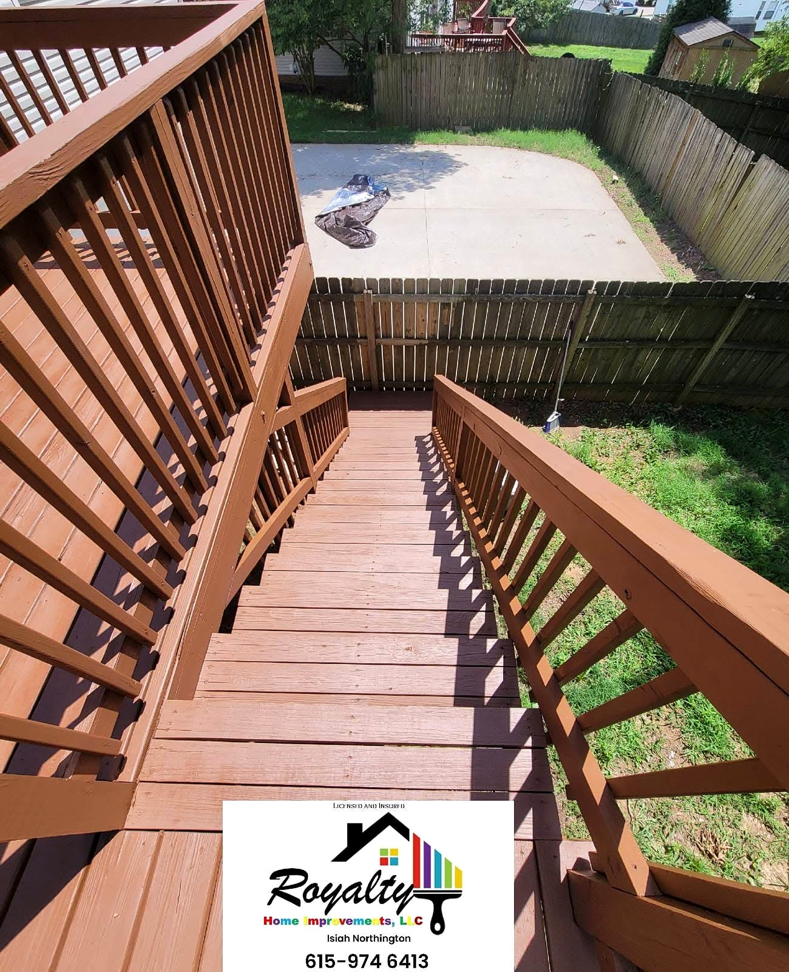 Freshly stained elevated deck and stairs overlooking a backyard