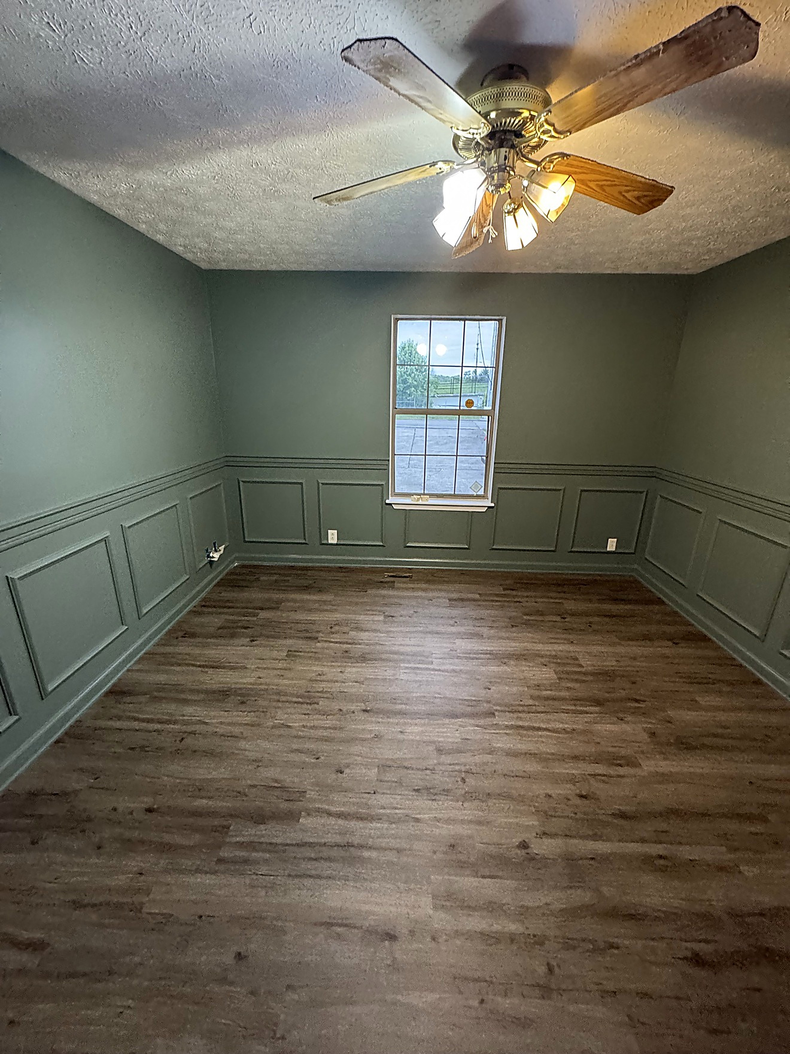 Finished hallway with a deep accent wall and wood flooring