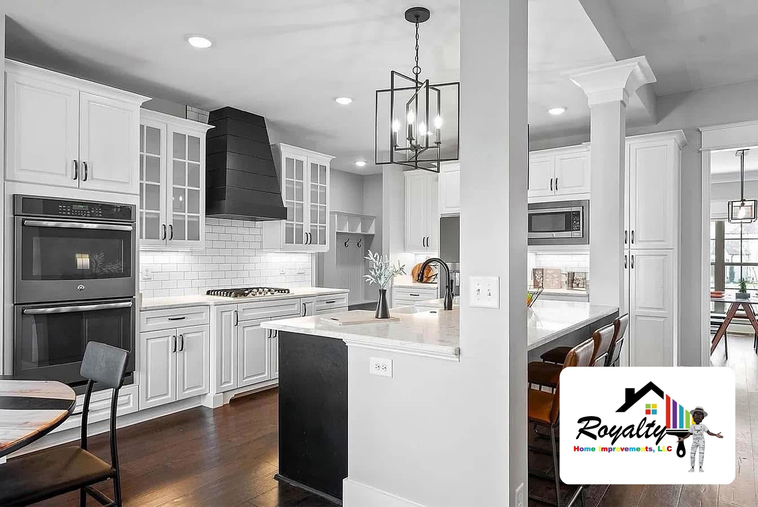 Modern white kitchen with a large island, dark countertops and pendant lights