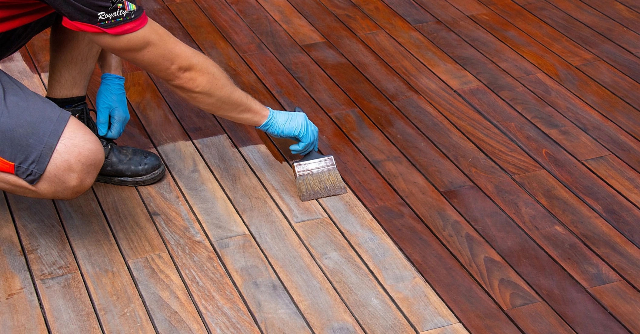 Professional in Royalty Home Improvement workwear staining deck boards